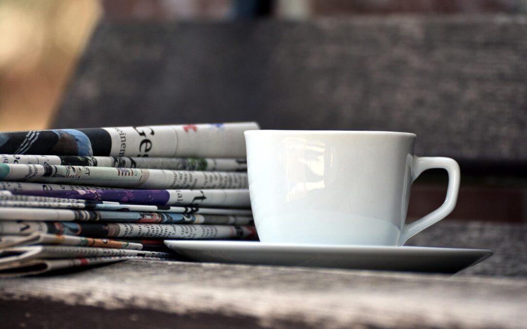Kaffeetasse und Stapel mit Zeitungen